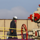 Heat from machinery distorts the air as a worker watches over a hydraulic fracturing operation.
